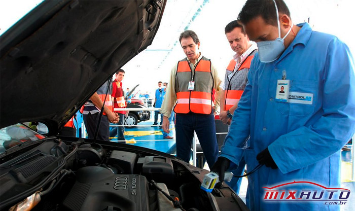 Gilberto Kassab junto a mecânico de uniforme azul durante Inspeção Veicular