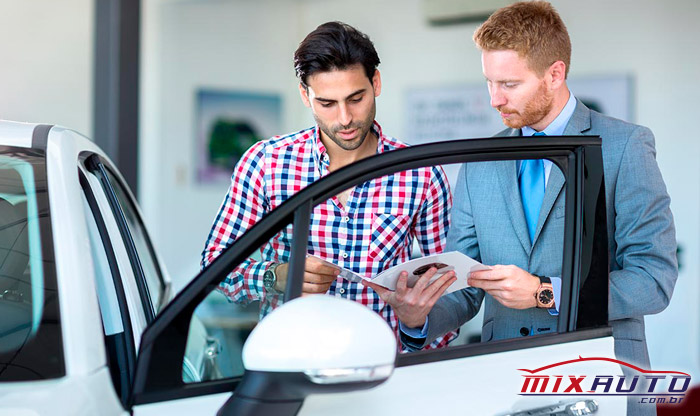 Foto de duas pessoas olhando o manual para verificar quando a manutenção preventiva automotiva deve ser realizada